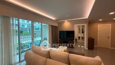 Spacious living room with modern decor and large windows overlooking a balcony.