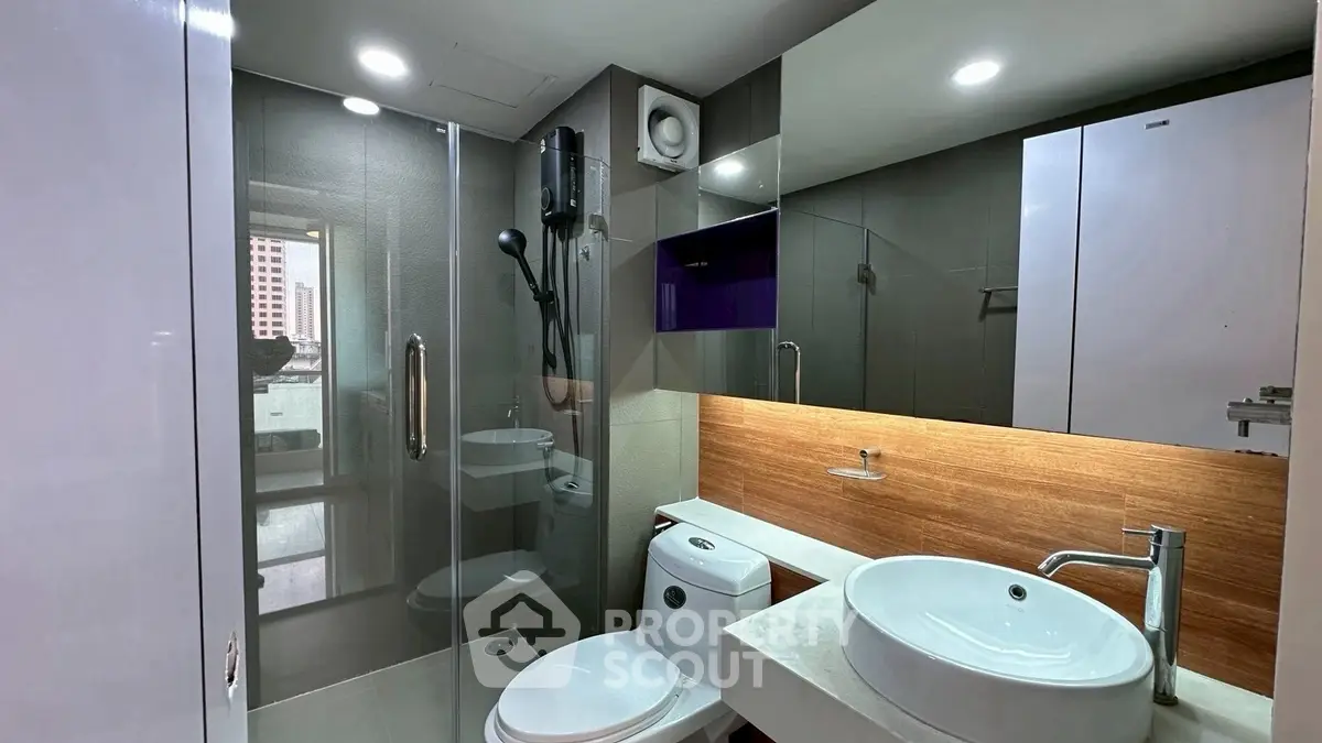 Modern bathroom with glass shower and stylish fixtures in urban apartment