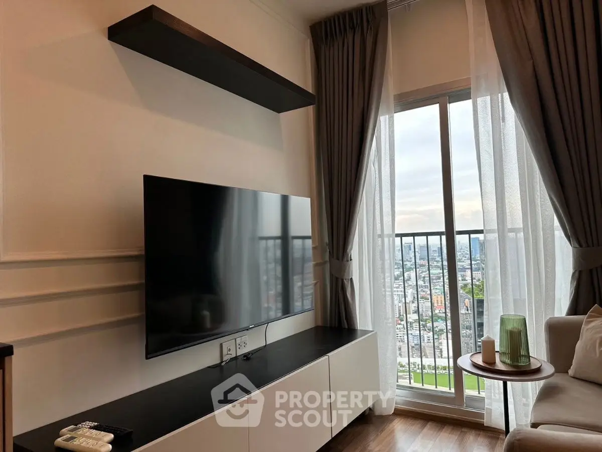 Modern living room with large TV and stunning city view from balcony