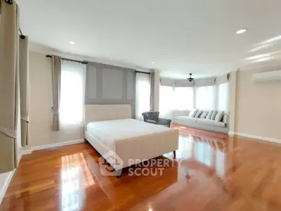 Spacious bedroom with elegant hardwood floors and ample natural light