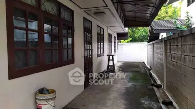 Charming exterior corridor with rustic windows and covered walkway, perfect for outdoor relaxation.