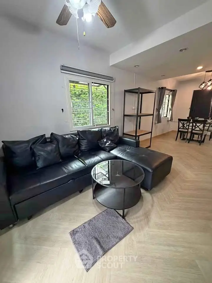 Modern living room with black leather sofa and stylish decor
