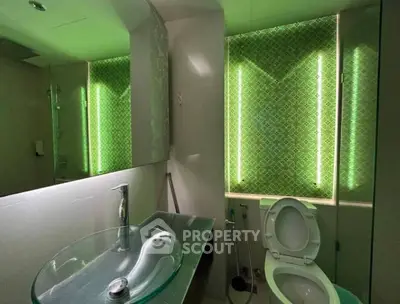 Modern bathroom with unique green LED lighting and glass sink