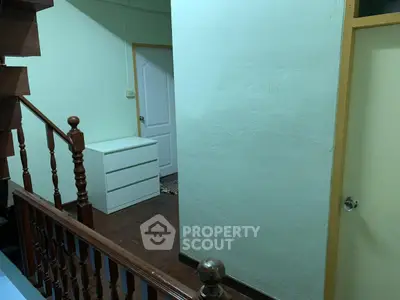 Cozy interior hallway with wooden staircase and white dresser