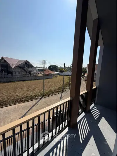 Spacious balcony with scenic view of suburban neighborhood and clear blue sky.