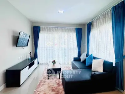 Modern living room with sleek furniture and large windows for natural light.