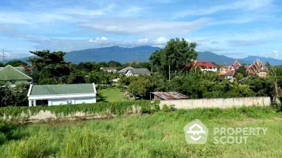 Scenic view of residential area with lush greenery and mountain backdrop