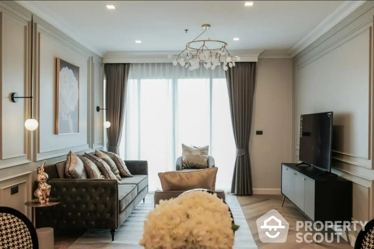 Luxurious living room with elegant decor and modern furniture, featuring a stylish chandelier and large windows.