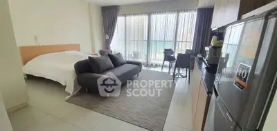 Modern studio apartment with cozy living area and balcony view