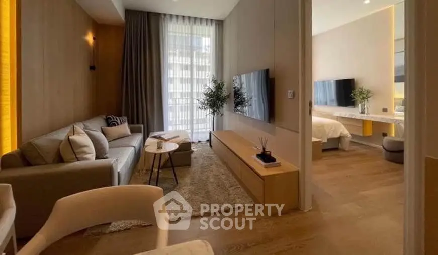Modern living room with cozy seating and stylish decor leading to a chic bedroom.