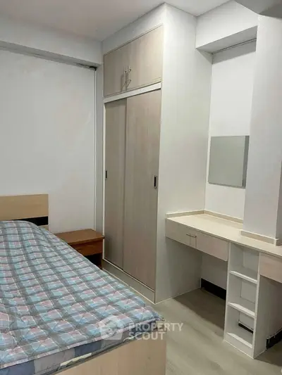 Cozy bedroom with built-in wardrobe and dressing table, perfect for modern living.