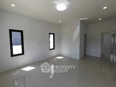 Spacious and bright empty room with modern tiled flooring and natural light.