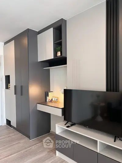 Modern living room with sleek built-in storage and flat-screen TV, perfect for contemporary urban living.