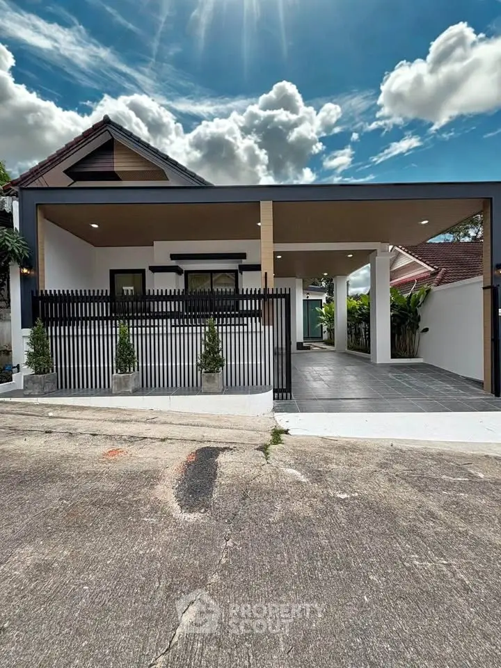 Charming modern house with sleek exterior design and spacious driveway under a bright blue sky.
