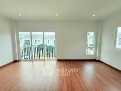 Spacious living room with large windows and balcony access in modern home