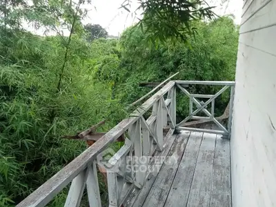 Charming rustic balcony surrounded by lush greenery, perfect for nature lovers seeking tranquility.