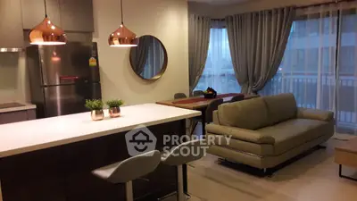 Modern open-layout kitchen and living room with stylish decor and natural light.