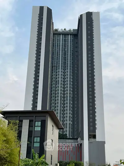 Stunning modern high-rise building with sleek design and lush rooftop garden.
