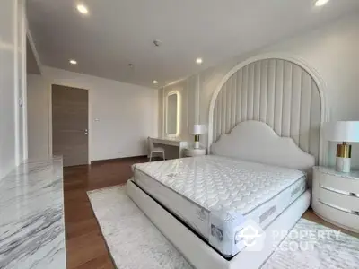 Luxurious spacious bedroom with marble flooring, elegant white bed, and modern furniture, perfect for upscale living.