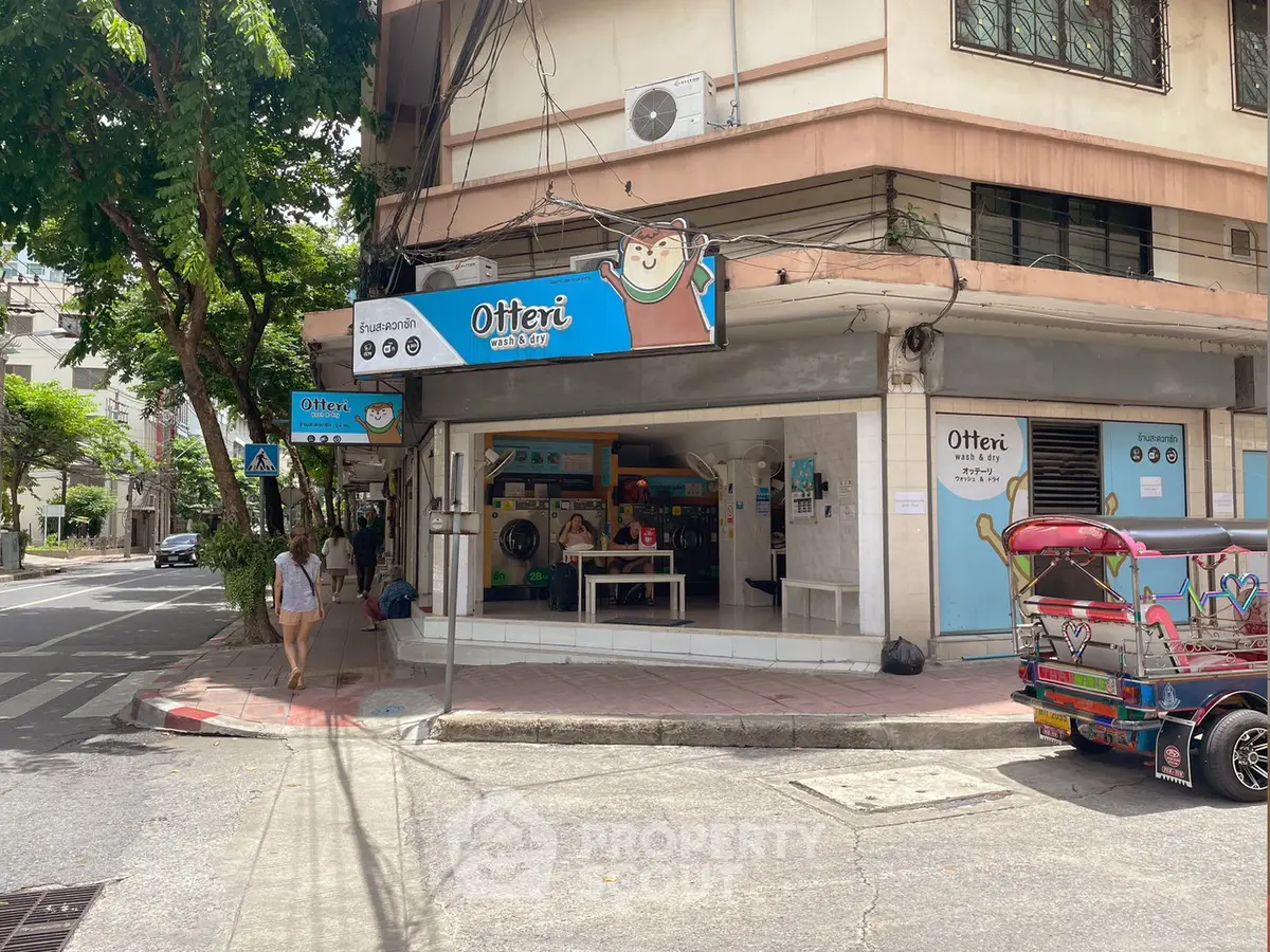 Charming corner laundromat with vibrant signage on a bustling street corner, perfect for urban convenience.