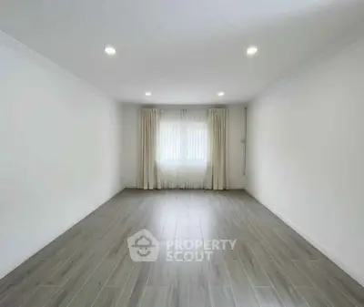 Spacious empty room with elegant flooring and natural light, perfect for customization.