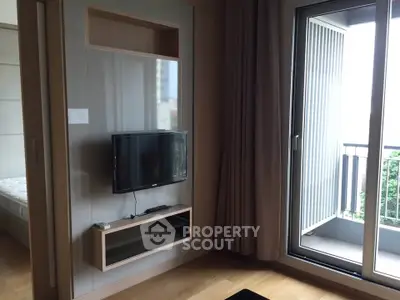 Modern living room with wall-mounted TV and balcony access