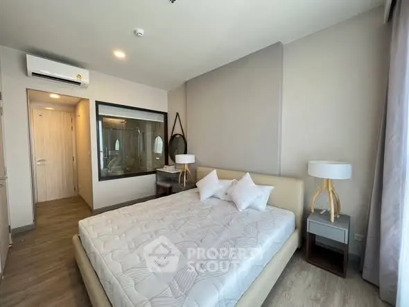 Modern bedroom with stylish decor and large window offering natural light.
