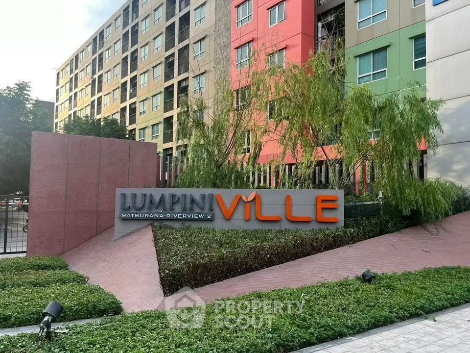 Modern apartment complex exterior with colorful facade and lush greenery.