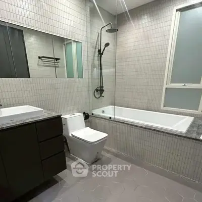 Modern bathroom with sleek fixtures and a spacious bathtub in a contemporary apartment.