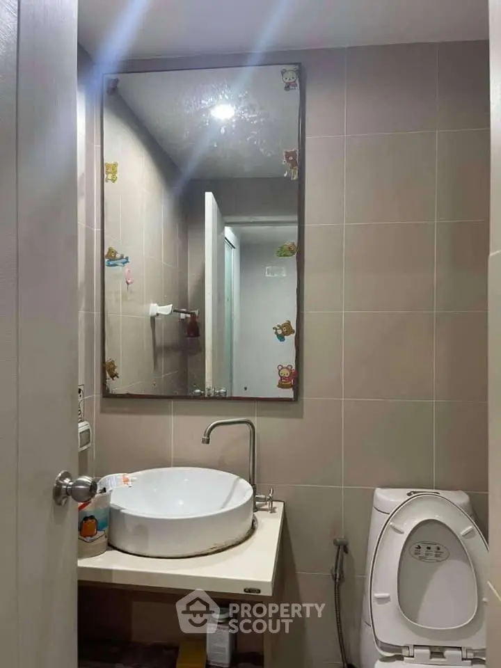 Modern bathroom with stylish sink and mirror, featuring cute decorative stickers.