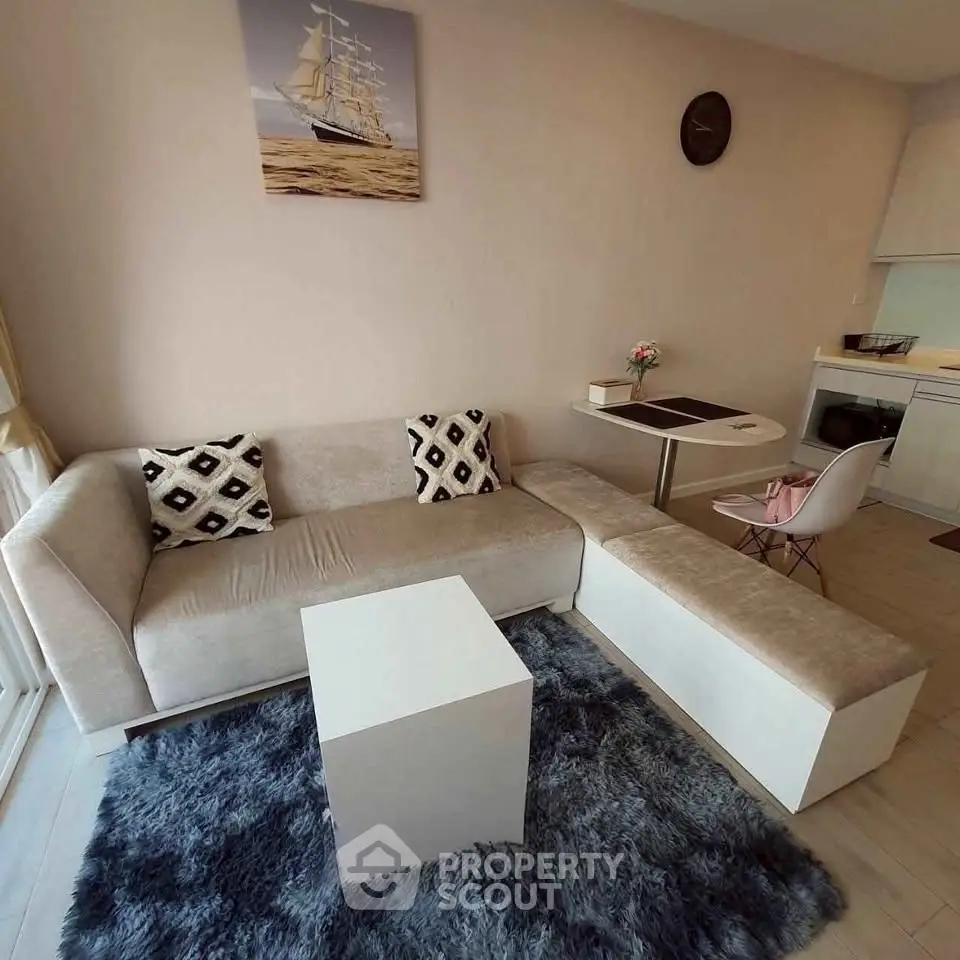 Modern living room with plush sofa, stylish decor, and compact dining area in a cozy apartment.