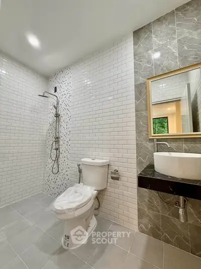 Modern bathroom with sleek design, featuring a walk-in shower and elegant fixtures.