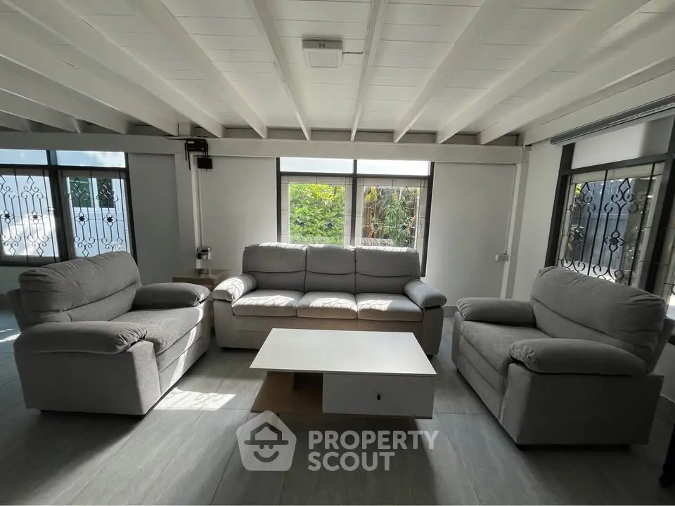 Spacious living room with modern gray sofas and large windows for natural light.