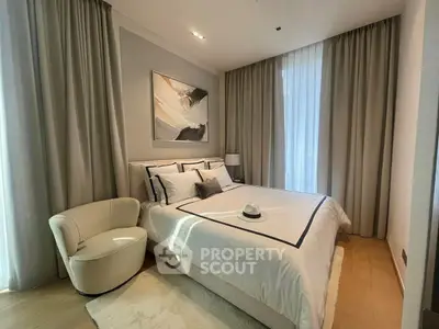 Elegant bedroom with modern decor and natural light, featuring a cozy chair and stylish bedding.