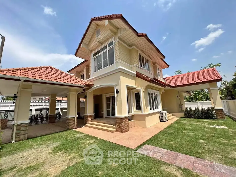 Charming two-story house with red-tiled roof and spacious green lawn under clear blue sky.