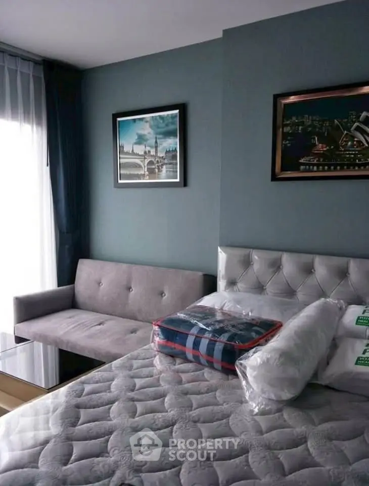 Modern bedroom with stylish decor and natural light, featuring a plush bed and cozy seating area.
