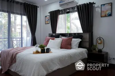 Cozy bedroom with large windows, stylish decor, and a comfortable bed, perfect for relaxation and rest.