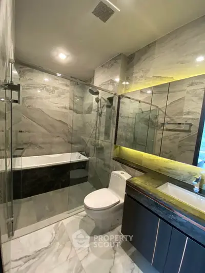 Luxurious modern bathroom with marble tiles and glass shower enclosure