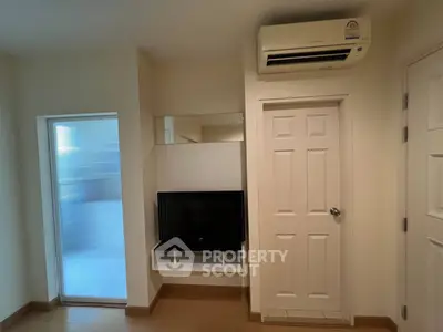 Modern living room with air conditioning and TV setup, featuring sleek design and neutral tones.