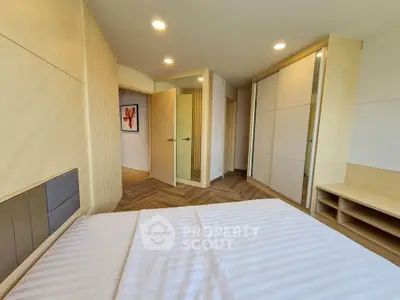 Spacious modern bedroom with wooden flooring and ample closet space