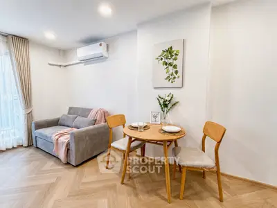 Charming living room with cozy dining area and modern decor in a stylish apartment.