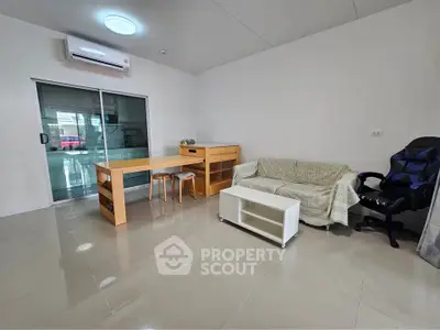 Modern living room with sleek furniture and air conditioning, featuring a cozy sofa and stylish dining area.