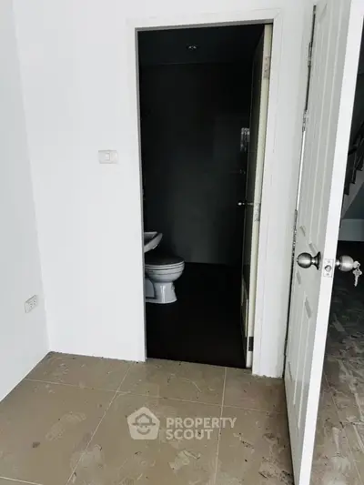 Unfinished bathroom with open door and visible toilet in a new construction property.
