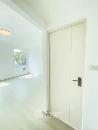 Bright and airy interior with modern door and large window, perfect for natural light lovers.