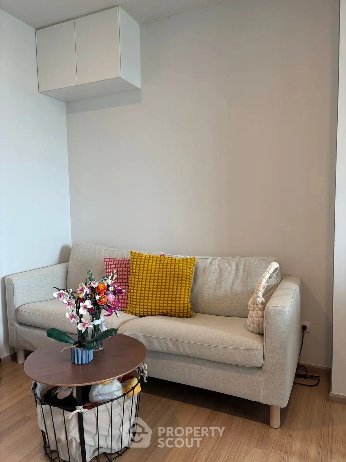 Cozy living room with modern sofa and vibrant cushions, perfect for relaxation.