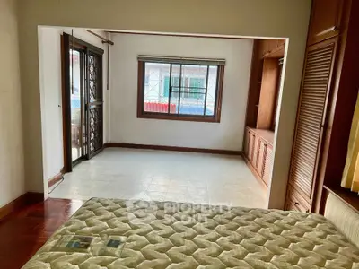 Spacious bedroom with large window and built-in storage, ideal for comfortable living.
