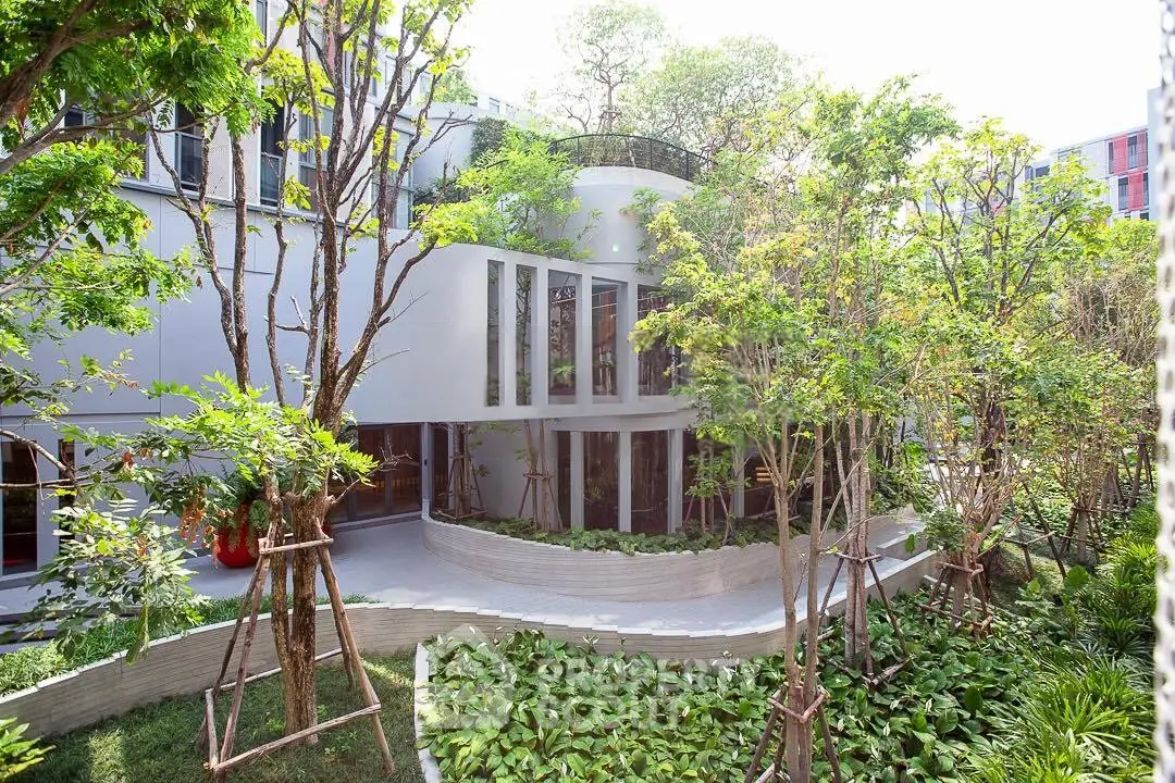 Modern building with lush garden and large windows, offering a serene and green living environment.