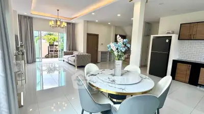 Elegant open-plan living and dining area with modern decor and abundant natural light.