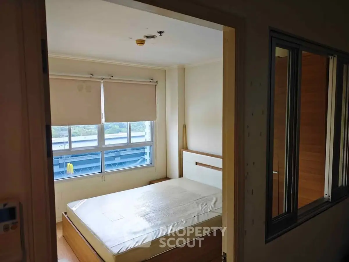 Cozy bedroom with large window and natural light in modern apartment