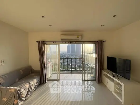 Spacious living room with balcony and city view, featuring modern furnishings and natural light.